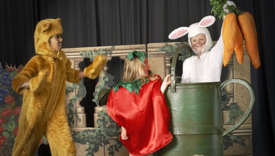 Three young children are dressed in costume and performing on stage.