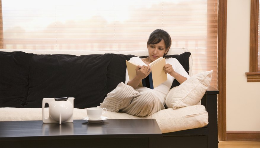 Woman reading a book on couch.