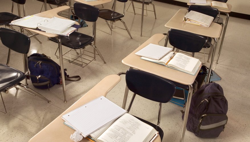 Empty classroom with desks and workbooks.