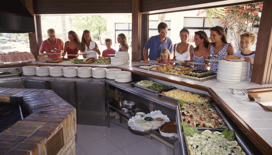 A group of people are standing at a buffet.