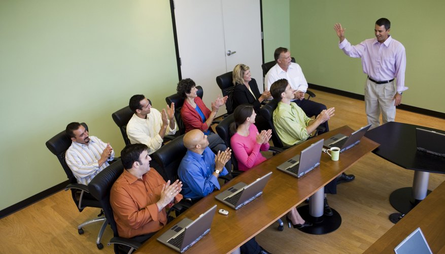 Office applauding as man finishes speech.