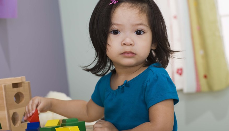 Young girl playing with building blocks.