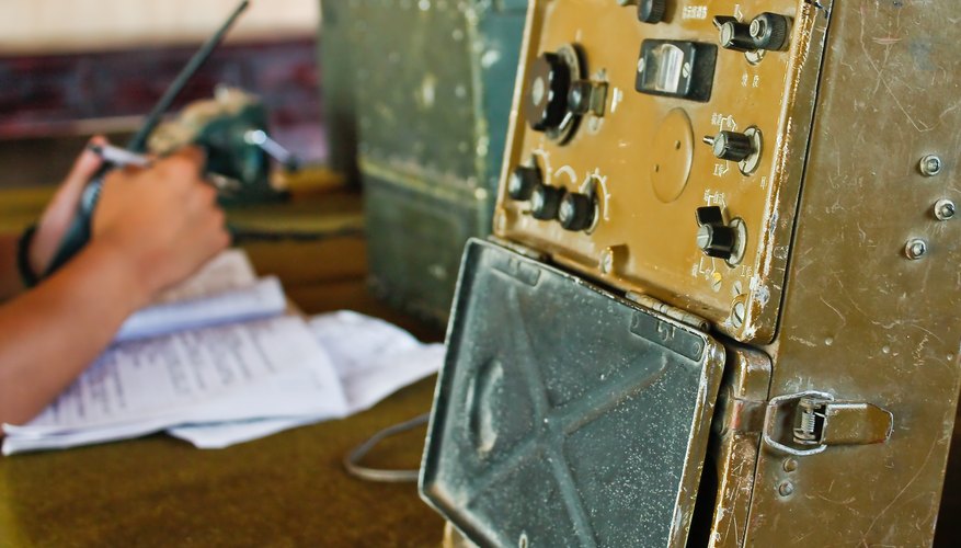 A close-up of a military radio in a control room.