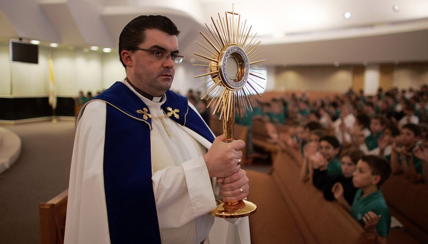 Rev. carries a monstrance during a mass in Boca Raton, FL.