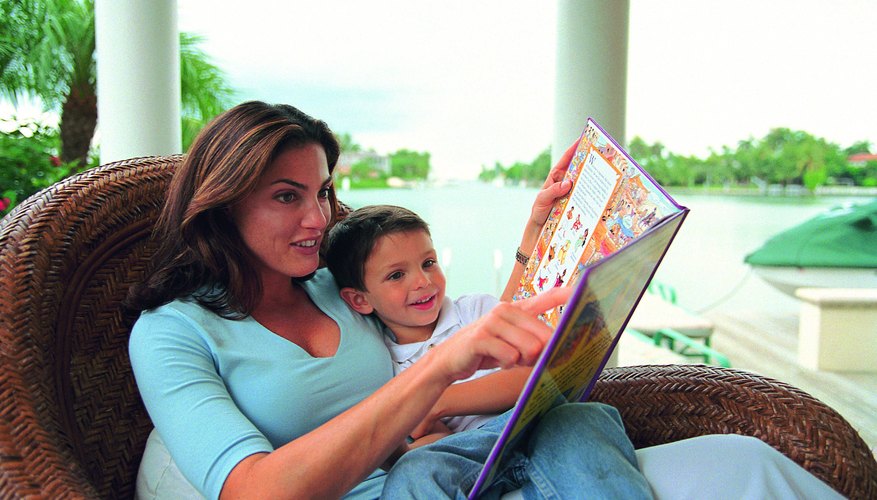 Young child reading picture book with mother