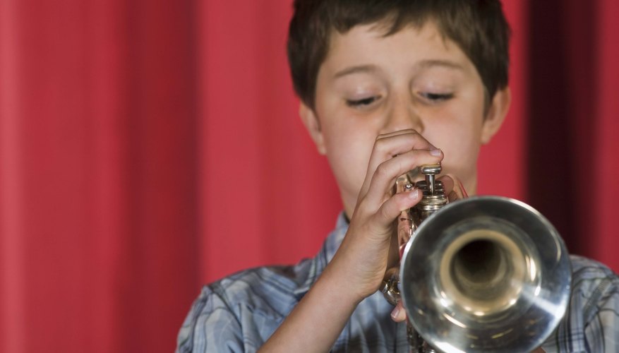 Boy playing trumpet on a stage.