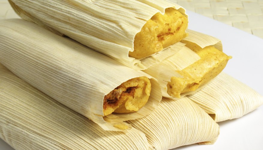 Close-up of tamales stacked on small plate.