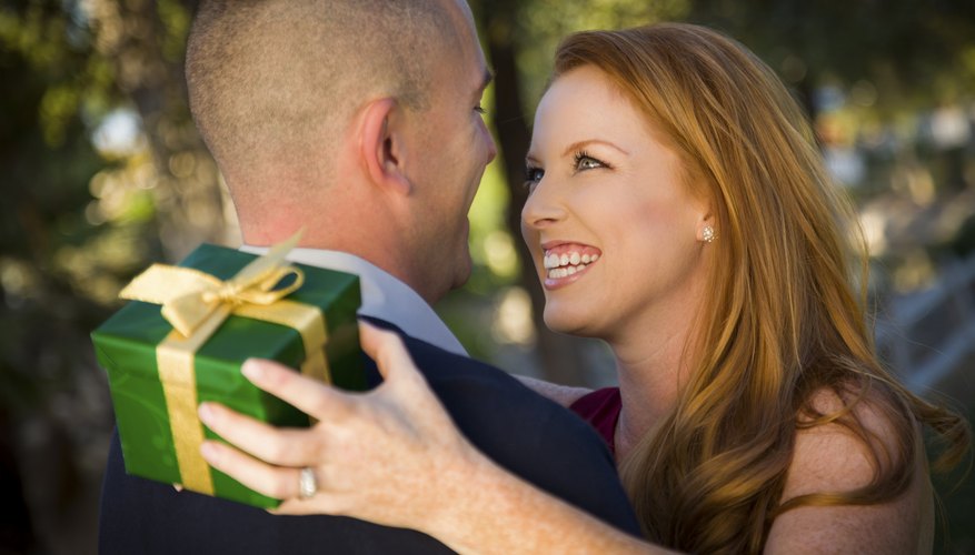 A military man and a smiling woman are exchanging gifts.