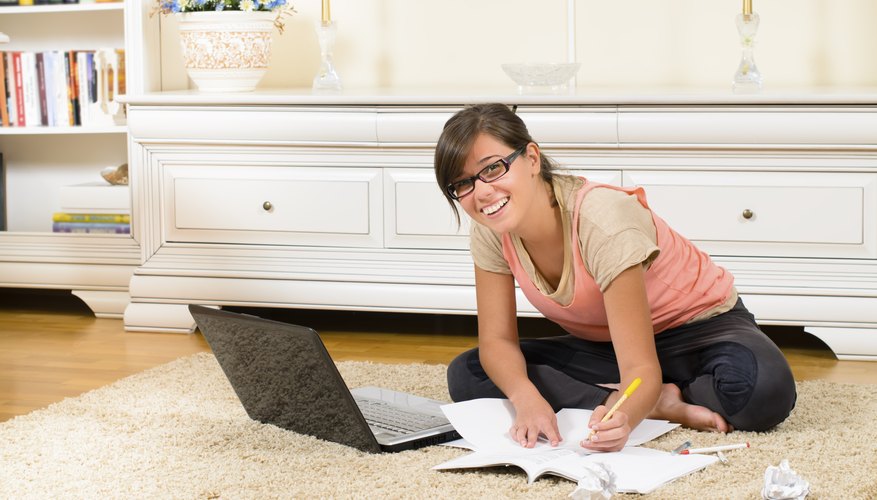 High school student working on essay at home.