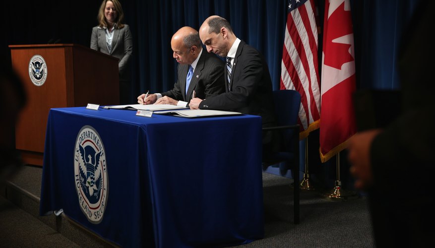 A Homeland Security official signing a foreign policy contract with a Prime Minister.