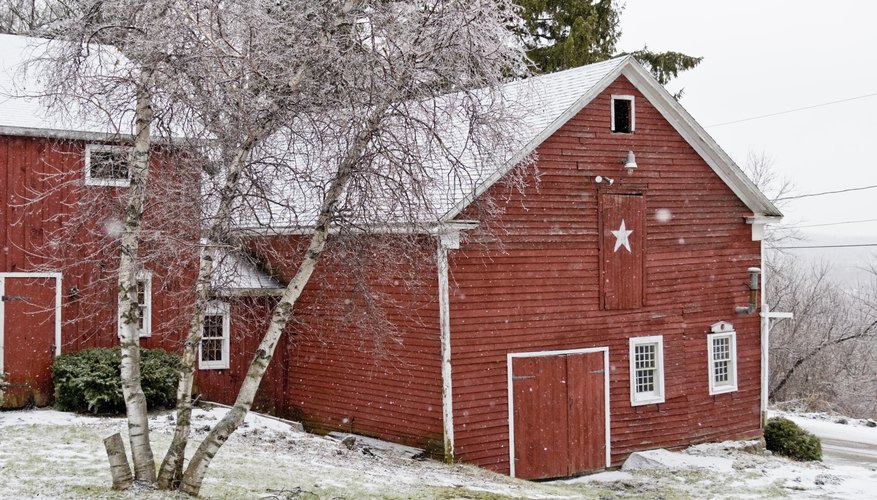 A white star on the front of a red barn on a winter morning.