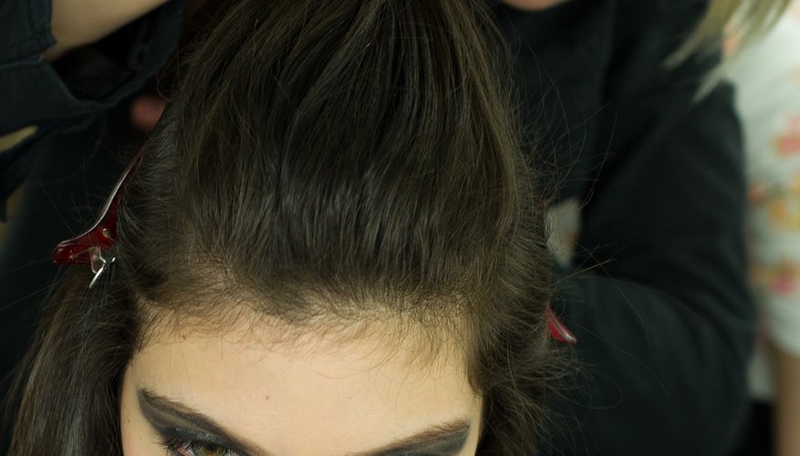 A hairstylist crafts a poof on a model backstage during Hong Kong Fashion week in January 2014.