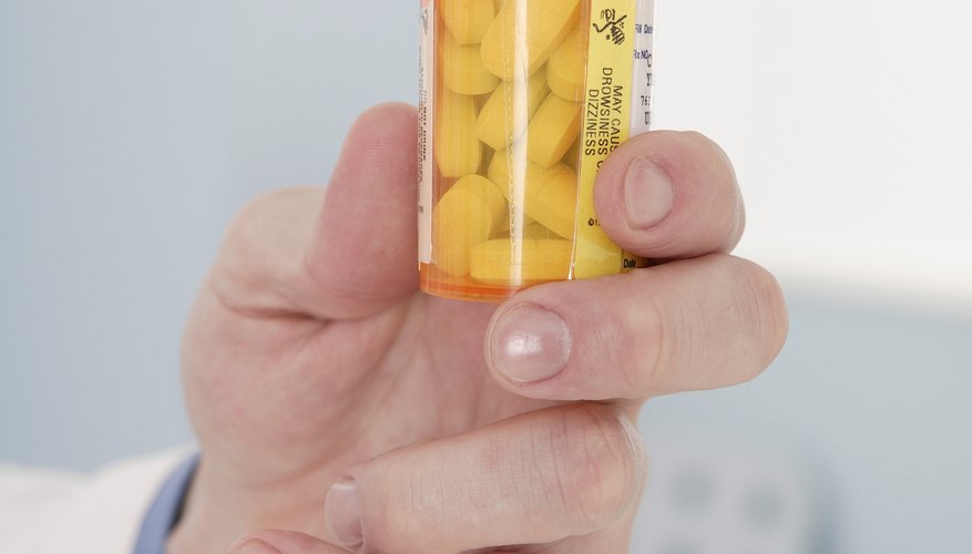 Close-up of a man holding a prescription pill bottle