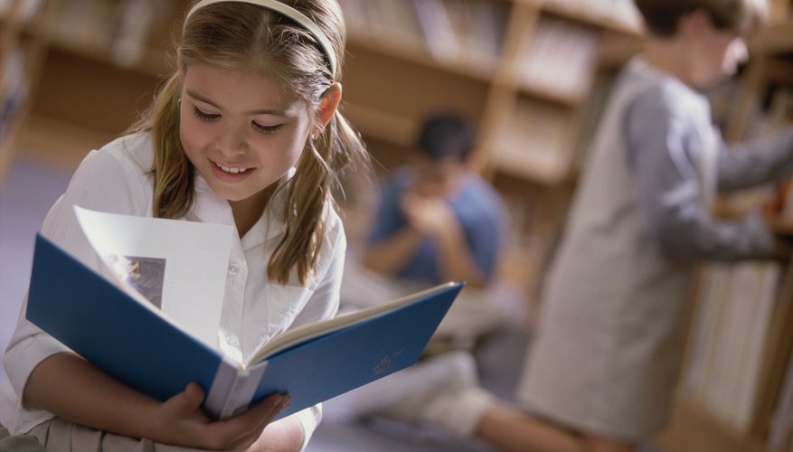 Child flipping through book in library.