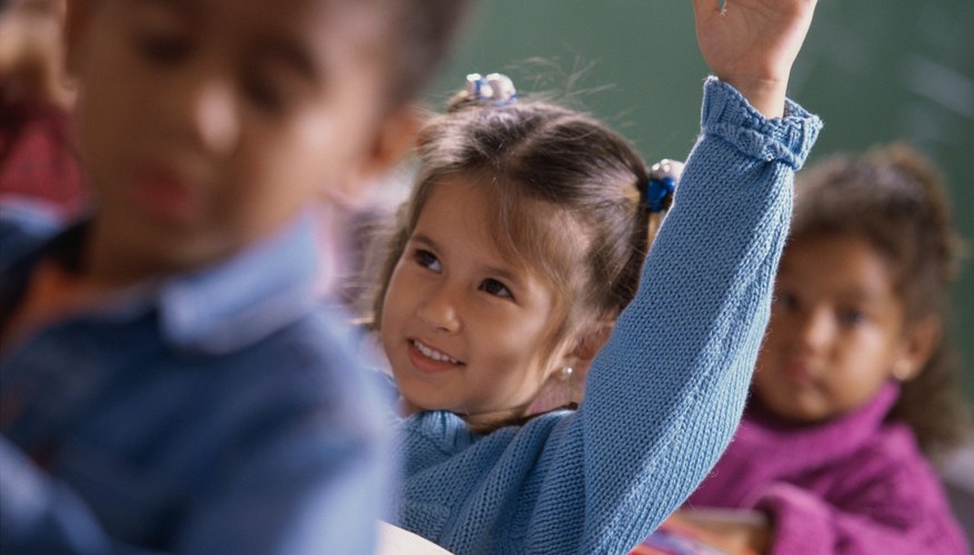 Little girl raising hands in class