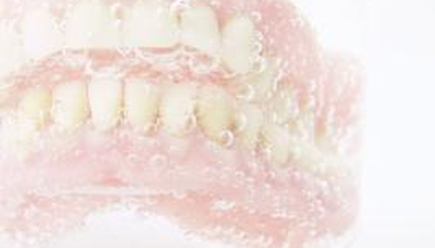 Soaking dentures in water is OK, soaking them in straight bleach is not.