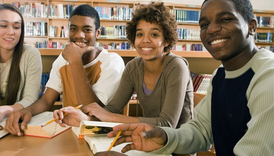 Smiling high school students in library.