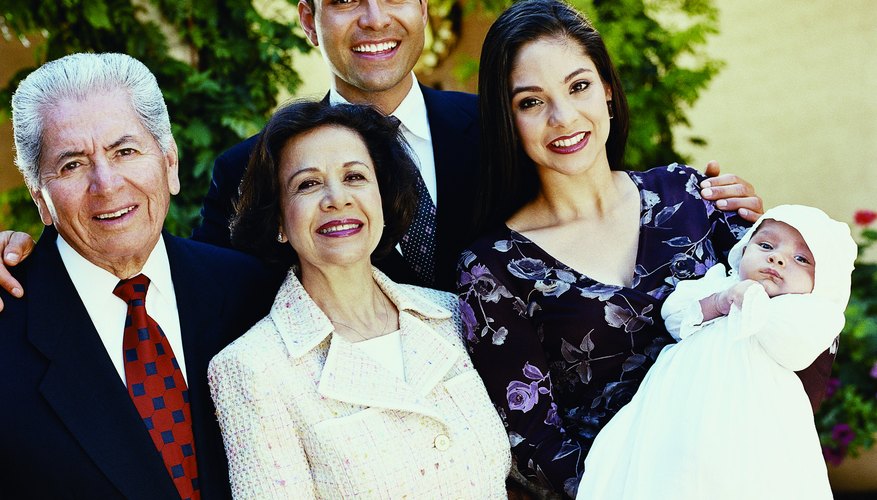 Godparents stand beside a child and her parents at the baptism ceremony.