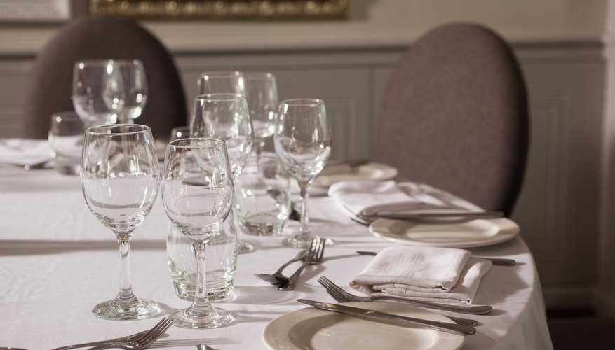 Fancy table set up with glasses, plates and silverware