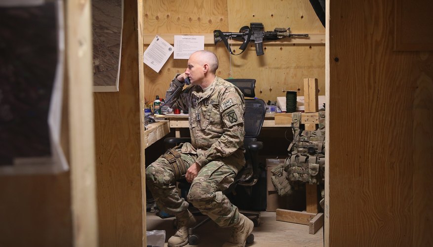 A soldier answers the telephone in an office.