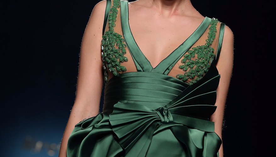 A model's smoky eye makeup highlights her emerald green ensemble.