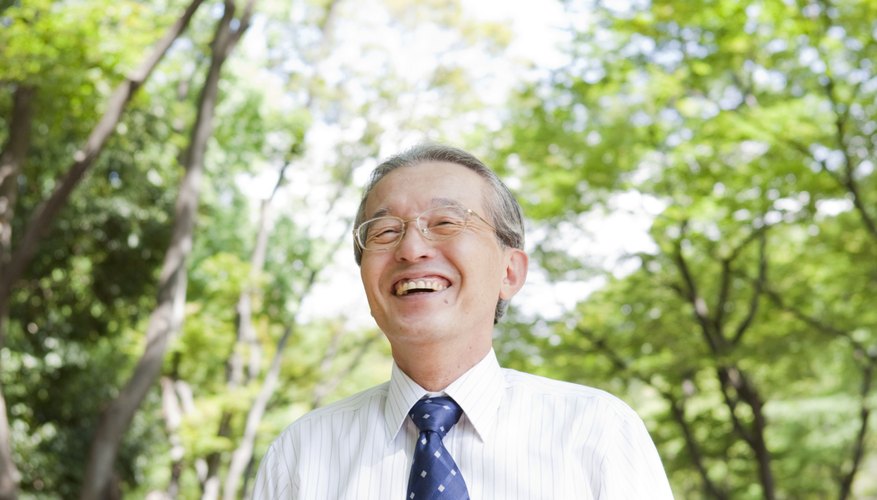 Senior businessman in park smiling