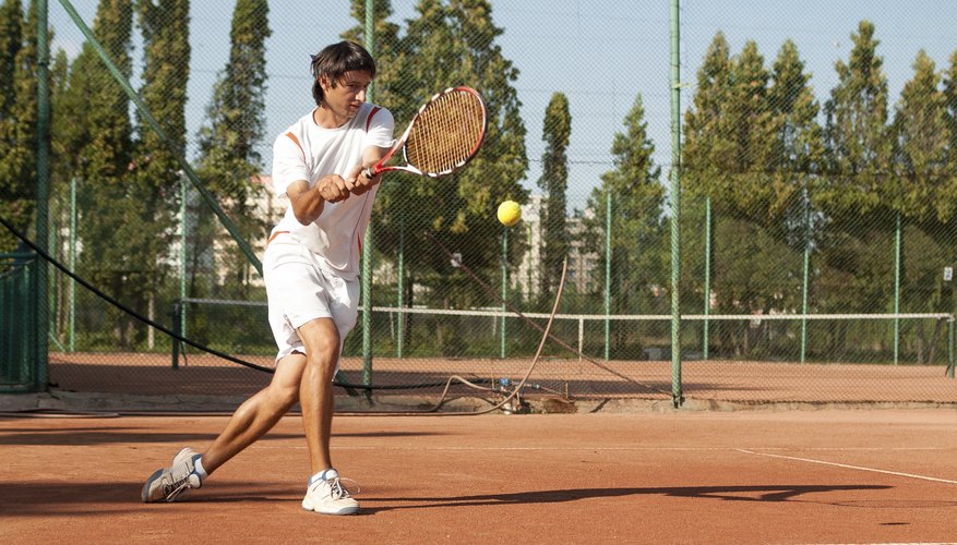 A man taking a backhand swing.