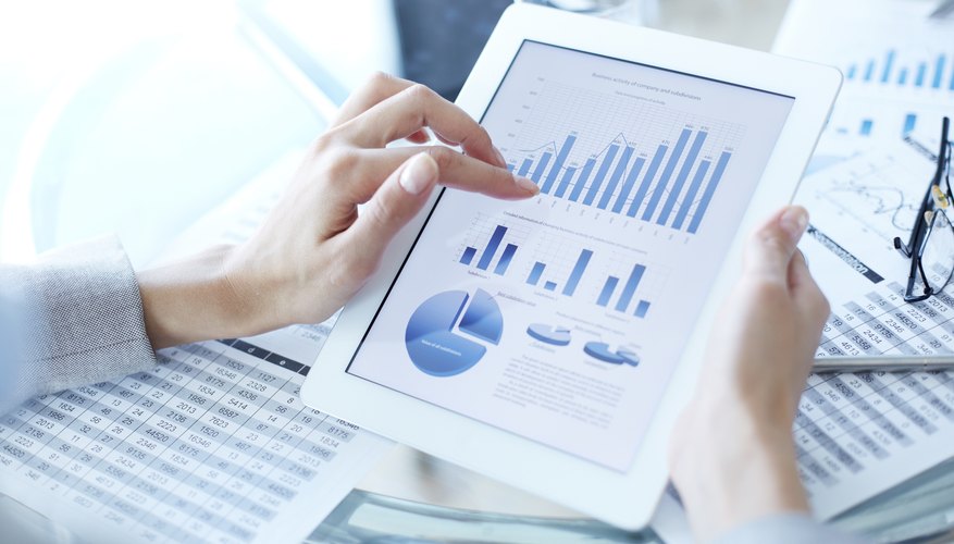 Close-up of woman holding iPad with different graphs on screen
