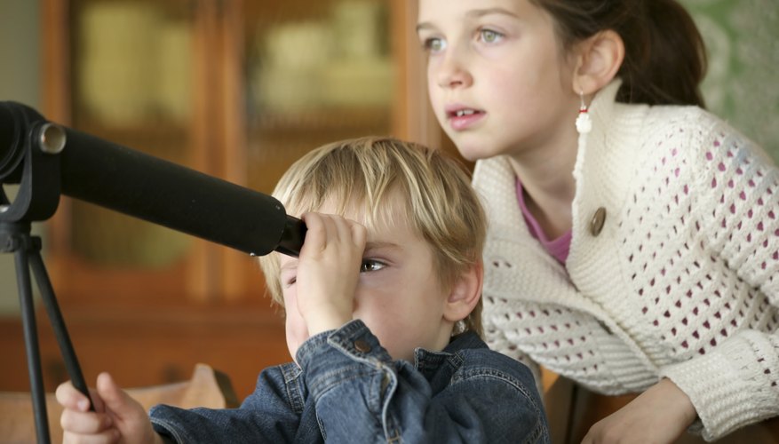 Young children looking through telescope
