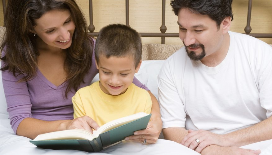 Child reading book with parents