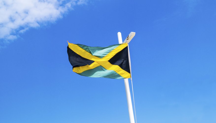 A Jamaican flag flying on the mast of a boat.