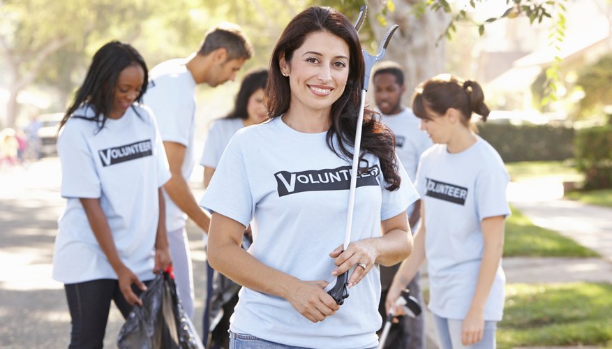 A woman and team volunteering to help clean the community.