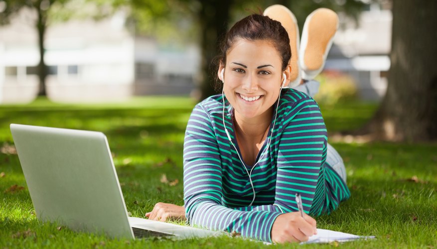 Student working on laptop while wearing earbuds