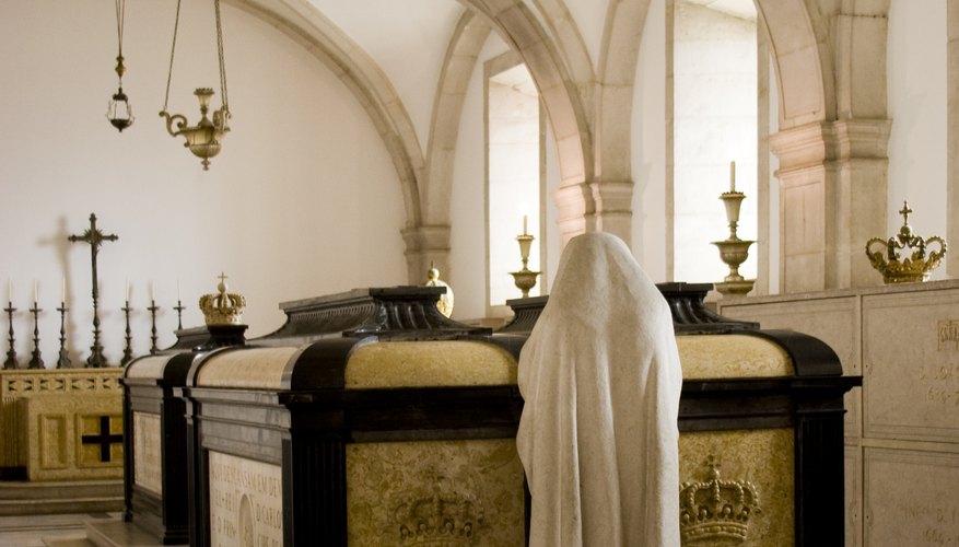A statue in front of a tomb in a mausoleum.
