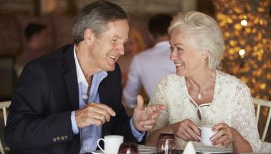 Dos personas felices conversan en una mesa apartada de un restaurante.