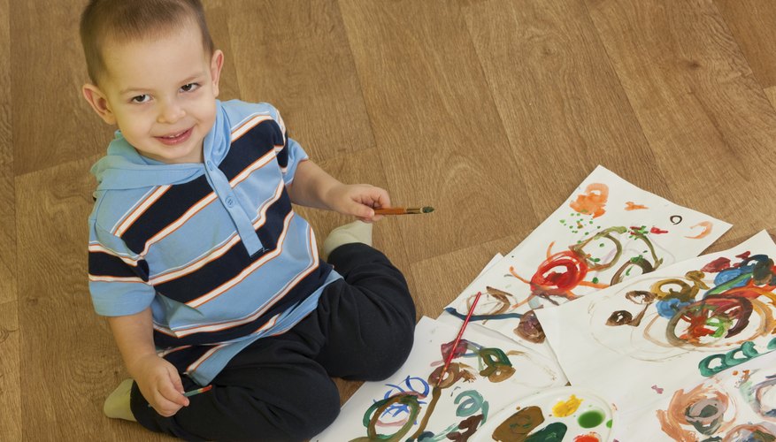 Toddler boy painting pictures.