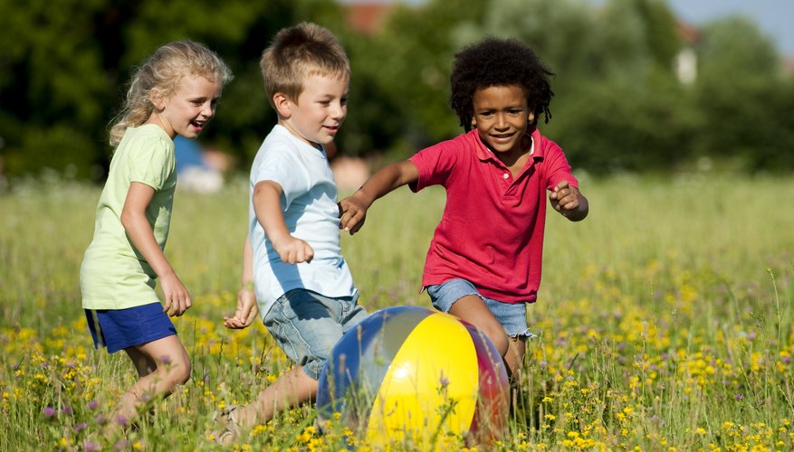 Preschoolers playing with an inflatable ball.