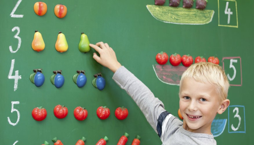 First grader counting numbers on chalkboard