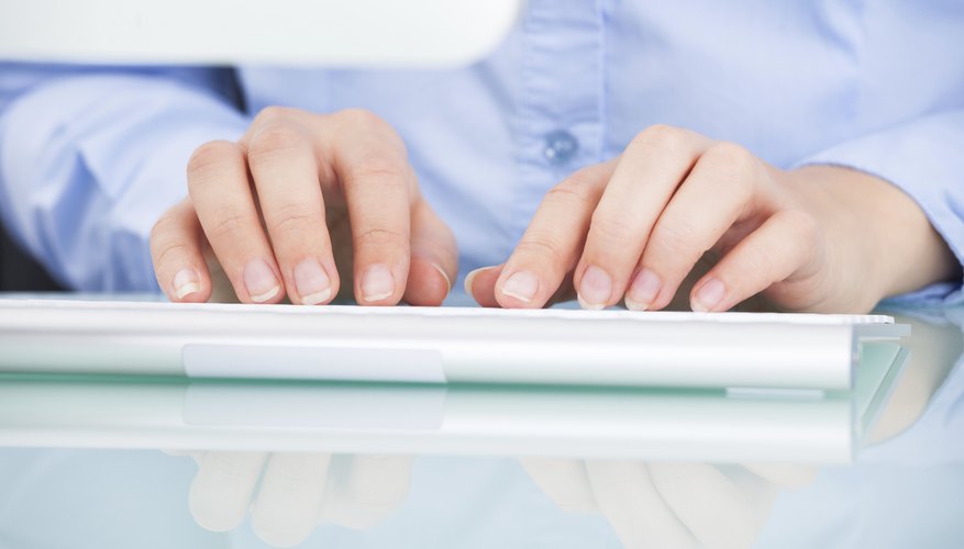 Close-up of hands typing on keyboard