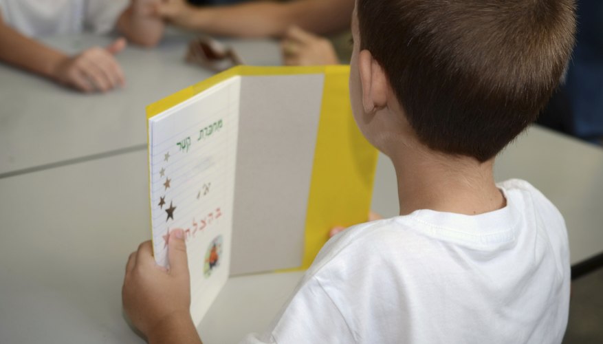 First grader holding up small book.