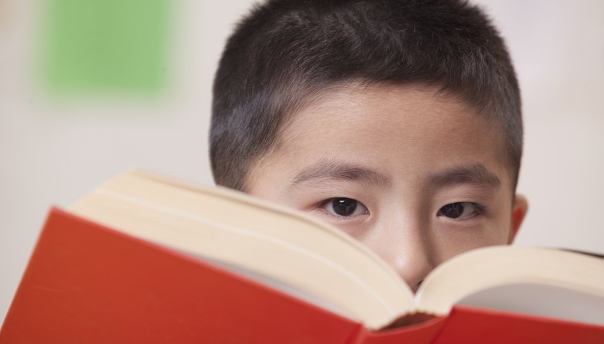 Close-up of student looking over book in classroom.
