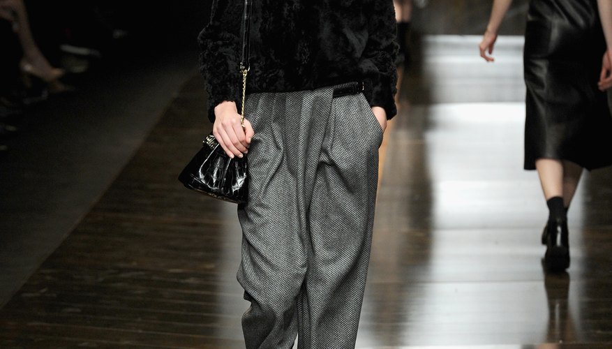 A model wears dark gray pants with a black sweater during Milan Fashion Week in 2014.
