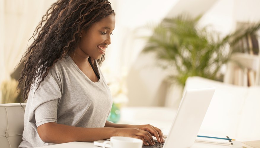 A young female student types on her laptop