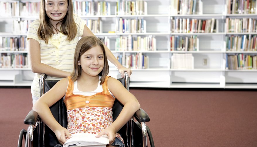 Student helping another student in a wheelchair in the school library.