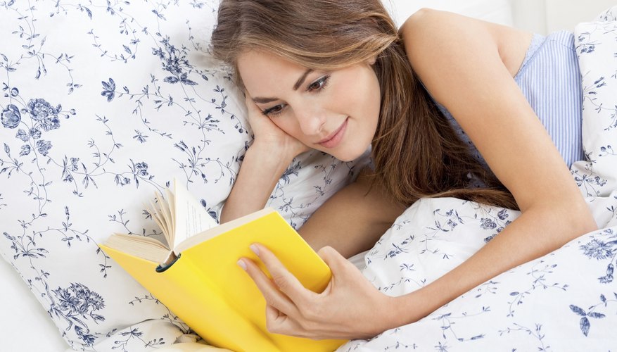 Woman reading book in bed