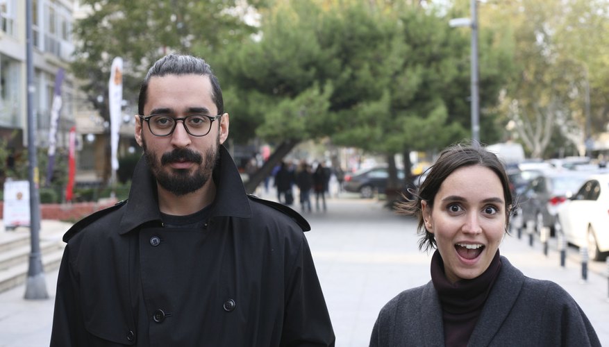 A well-dressed couple enjoying a walk up the street.