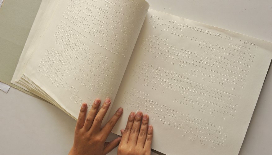 An overhead view of a child reading Braille.