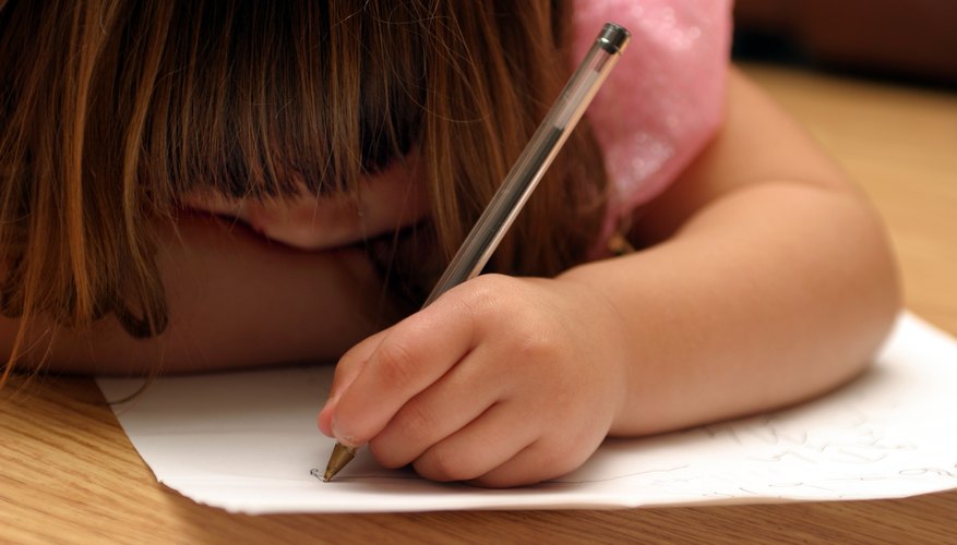 Young child writing with her left hand.