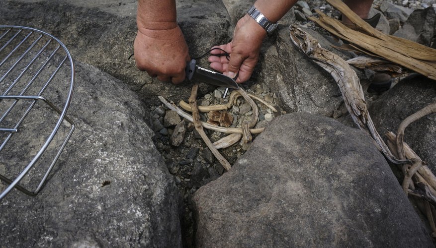 Two hands making fire with flint tool
