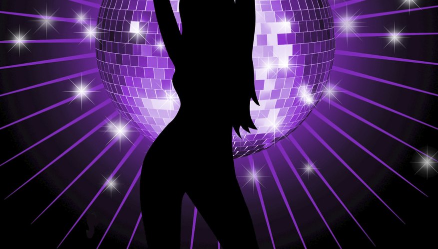 The disco ball sends sparkling light around the room, highlighting the dancers.